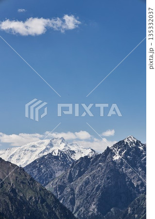 Majestic snow-capped mountain peaks under a clear blue sky, natural grandeur Majestic snow-capped mountain peaks under a clear blue sky, natural grandeur 135332037