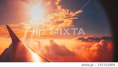 Golden sunset clouds above earth view from airplane window during flight Golden sunset clouds above earth view from airplane window during flight 135332864