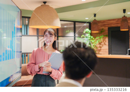 モダンオフィスでプレゼンをする若い女性 135333216