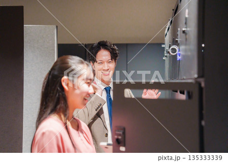 オフィスのロッカーで会話をする男女の会社員 135333339