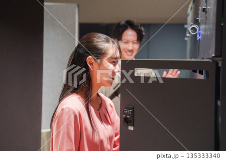 オフィスのロッカーで会話をする男女の会社員 オフィスのロッカーで会話をする男女の会社員 135333340