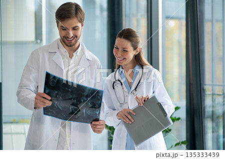 Doctors looking at the xray results and looking interested Doctors looking at the xray results and looking interested 135333439