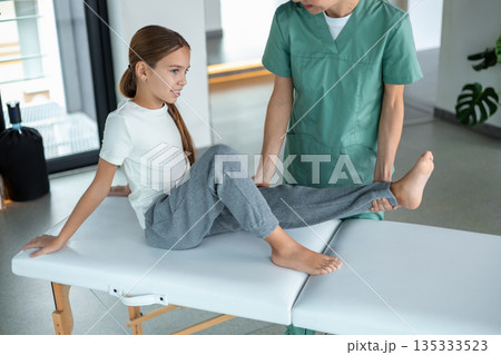 Professional healthcare worker guiding patient in movement therapy 135333523