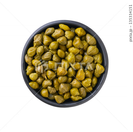 pickled capers in a black ceramic bowl isolated on a white background, top view. pickled capers in a black ceramic bowl isolated on a white background, top view. 135334151