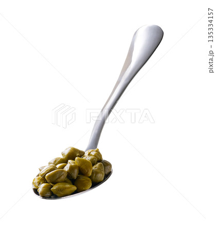 Spoon with pickled capers isolated on a white background. Spoon with pickled capers isolated on a white background. 135334157