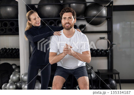 Blonde young female coach training a young man during interval workout Blonde young female coach training a young man during interval workout 135334187