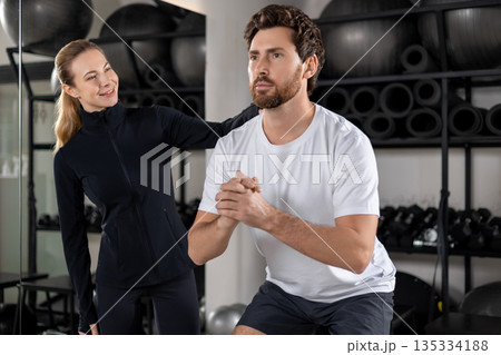 Blonde young female coach training a young man during interval workout Blonde young female coach training a young man during interval workout 135334188