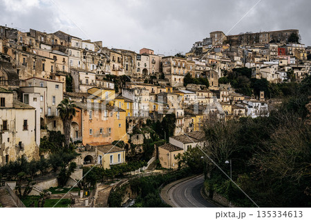 Hilltop City Of Ragusa In Sicily Under Overcast Sky: Historic Stone Buildings And Dense Urban Landscape In Soft Diffused Light And Hazy Weather 135334613
