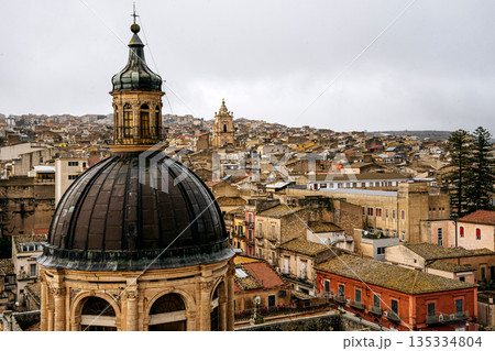 Panoramic View Over Ragusa From Cathedral Of San Giovanni Battista: Historic Sicilian City Rooftops, Church Domes, And Dense Stone Architecture Under Overcast Sky 135334804
