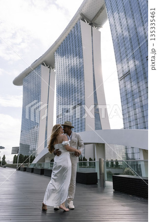 An international wedding. A handsome dark-skinned groom in a white suit 135335461