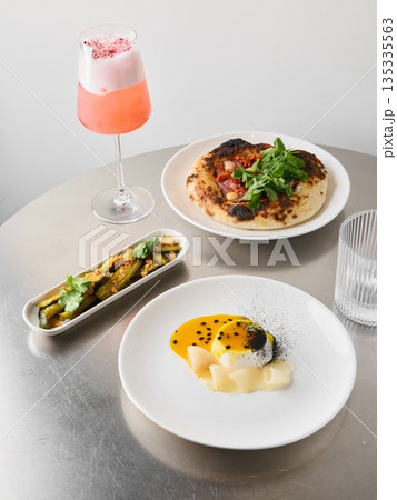 Chic signature drink paired with artistic culinary arrangement 135335563