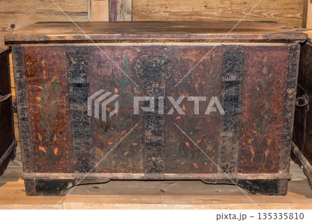 Old wooden chest against wooden wall 135335810