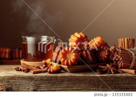 Cinnamon cakes and tea on an old wooden table. 135335883