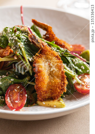 Warm salad with crispy fried shrimp cherry tomatoes fresh greens and sesame seeds Warm salad with crispy fried shrimp cherry tomatoes fresh greens and sesame seeds 135336413