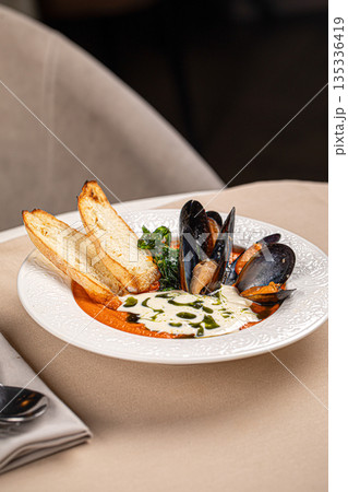 Mussels in creamy sauce with toasted bread 135336419