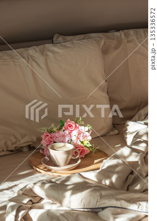 Cappuccino Cup and Flowers on Tray with Satin Bedding in Sunlight. Valentine's or Mother's Day Celebration 135336572