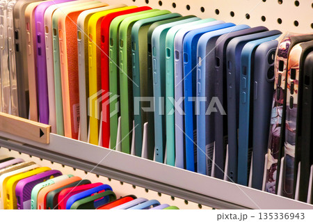 Colorful smartphone cases arranged on retail shelf in electronics store display Colorful smartphone cases arranged on retail shelf in electronics store display 135336943