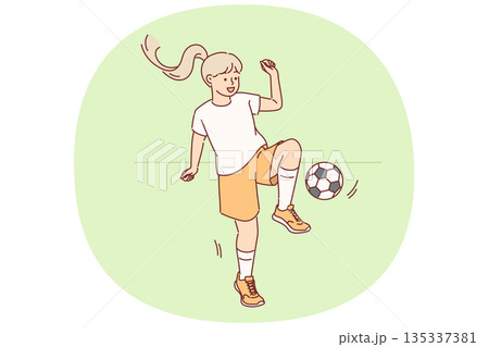 Little girl plays football with ball during outdoor training session preparing for school tournament 135337381