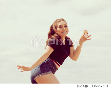 Young woman eating ice cream Young woman eating ice cream 135337521