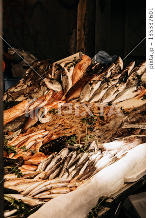 Fresh Seafood Display At Market Stall: Raw Fish, Squid, And Shellfish Arranged In White Crates On Ice In Indoor Food Market Setting Fresh Seafood Display At Market Stall: Raw Fish, Squid, And Shellfish Arranged In White Crates On Ice In Indoor Food Market Setting 135337601