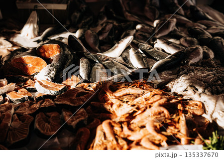 Fresh Seafood Display At Market Stall: Raw Fish, Squid, And Shellfish Arranged In White Crates On Ice In Indoor Food Market Setting Fresh Seafood Display At Market Stall: Raw Fish, Squid, And Shellfish Arranged In White Crates On Ice In Indoor Food Market Setting 135337670