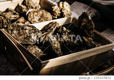 Fresh Oysters In Wooden Crate At Market Stall: Raw Shellfish Displayed With Rough Natural Shells In Traditional Seafood Market Scene 135337672