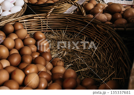 Fresh Brown Eggs In Wicker Basket: Natural Farm Eggs Arranged On Straw In Traditional Food Market Setting Fresh Brown Eggs In Wicker Basket: Natural Farm Eggs Arranged On Straw In Traditional Food Market Setting 135337681