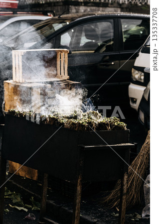 Fresh Artichokes Barbecue At Catania Market In Sicily: Trimming And Steaming Green Vegetables On Hot Surface In Traditional Street Food Scene 135337708