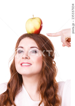 Woman funny girl holds on head apple fruit Woman funny girl holds on head apple fruit 135337834