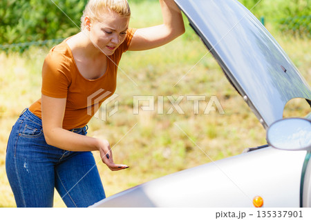 Woman standing near broken down car Woman standing near broken down car 135337901