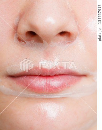 Close up woman in facial peel off mask. Close up woman in facial peel off mask. 135337918