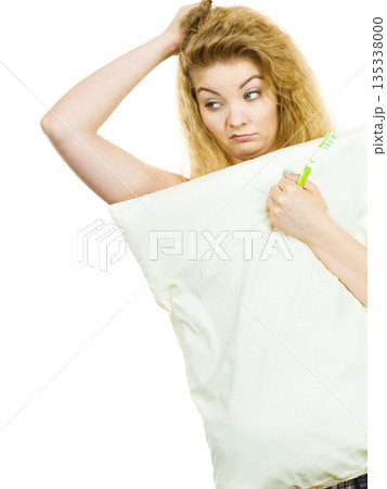Sleepy woman hugging white pillow 135338000
