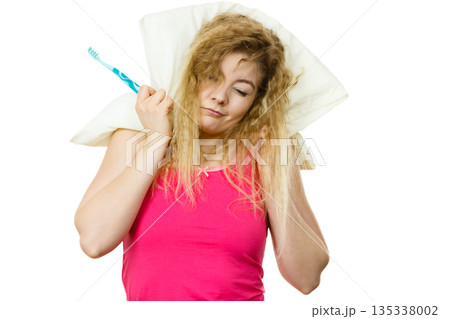 Sleepy woman hugging white pillow 135338002