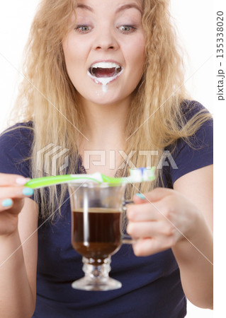 Happy woman holding toothbrush and coffee Happy woman holding toothbrush and coffee 135338020