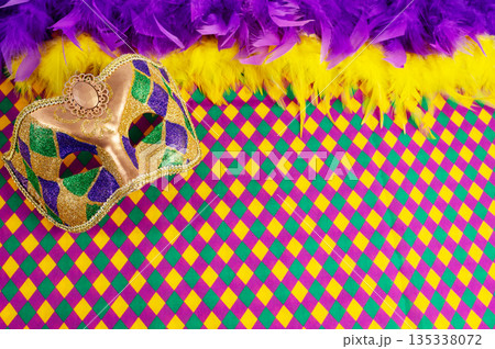 Top view of a beautiful composition of colorful masks, confetti, Mardi Gras decorations. Yellow Mardi Gras banner. Top view of a beautiful composition of colorful masks, confetti, Mardi Gras decorations. Yellow Mardi Gras banner. 135338072