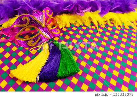 Top view of a beautiful composition of colorful masks, confetti, Mardi Gras decorations. Yellow Mardi Gras banner. Top view of a beautiful composition of colorful masks, confetti, Mardi Gras decorations. Yellow Mardi Gras banner. 135338079