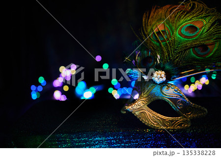 Masquerade mask with peacock feathers bringing mystery and celebration bokeh lights Masquerade mask with peacock feathers bringing mystery and celebration bokeh lights 135338228