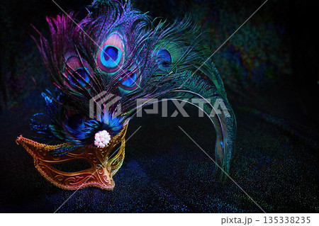 Golden venetian mask featuring vibrant peacock feathers Golden venetian mask featuring vibrant peacock feathers 135338235