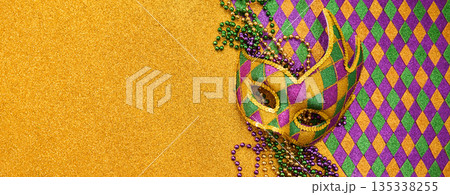 Mardi gras mask and beads on golden glitter background Mardi gras mask and beads on golden glitter background 135338255