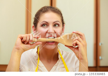 Housewife with ladle in kitchen 135338465