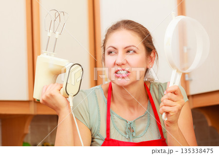 Housewife with mixer having fun in kitchen. Housewife with mixer having fun in kitchen. 135338475
