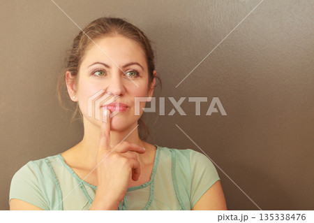 Thoughtful emotional woman in studio Thoughtful emotional woman in studio 135338476