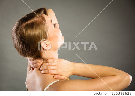 Woman suffering from neck pain Woman suffering from neck pain 135338623