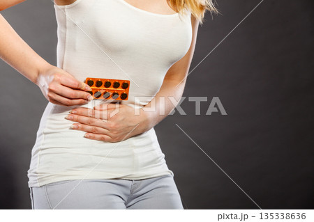 Woman suffer from belly pain holds pills Woman suffer from belly pain holds pills 135338636