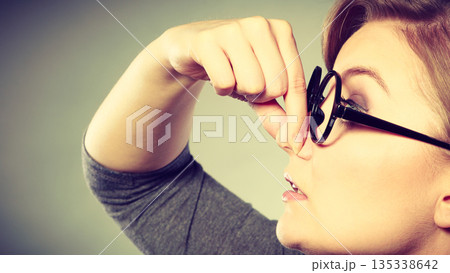 Girl pinches her nose because of stench stink. Girl pinches her nose because of stench stink. 135338642