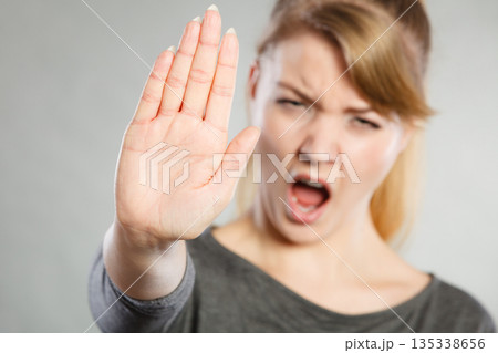 Female shows stop sign by her hand. 135338656