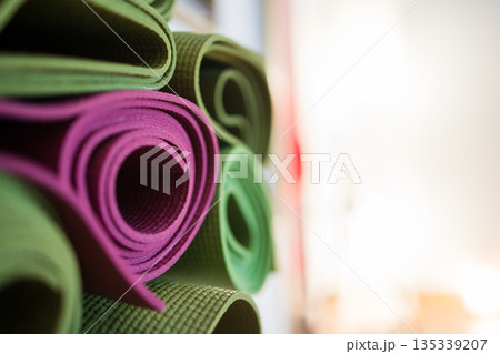 Rolled yoga mats stacked in studio 135339207