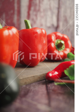 Fresh red peppers and chili peppers on a wooden board 135340808