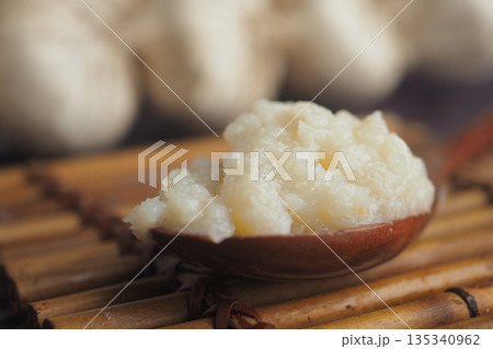 closeup of garlic paste on a wooden spoon closeup of garlic paste on a wooden spoon 135340962
