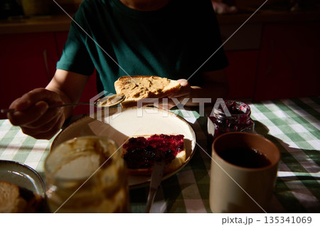 Family Breakfast Moment With Peanut Butter And Jelly On Toast At The Table 135341069